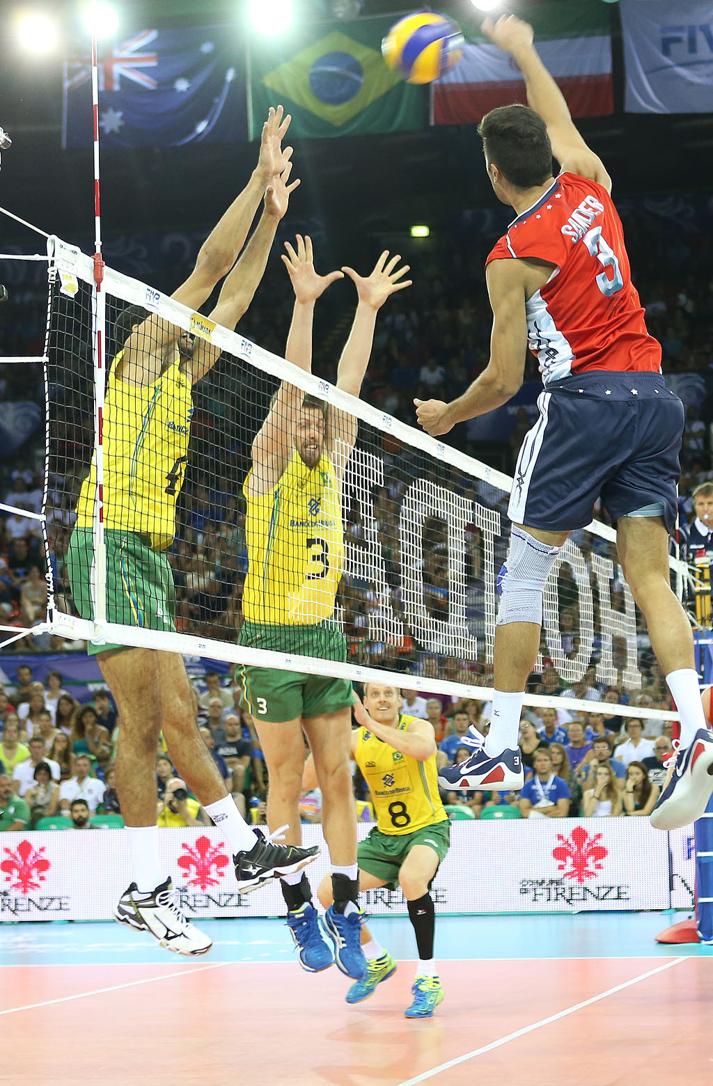 Taylor Sander (right) of USA spikes against De Souza and Carbonera (BRA)